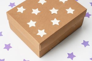 Wooden christmas gift box over white wall with stars