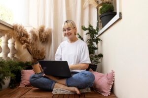 Young blonde woman working from home on the floor