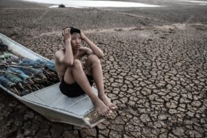 The boy sat on a fishing boat and caught his head on dry soil, global warming