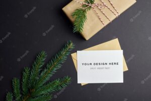 Christmas greeting card mockup with gift box and fir tree branches on black