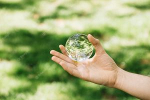 Close-up of hand holding transparent sphere at outdoors