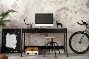 Concrete interior of home office with black desk computer screen office accessories lamp rack with personal accessories home decor template