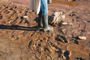 Crop woman standing in mud