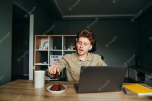 Freelancer sits at home at work with a laptop and eats cookies with tea remote work at home