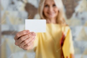 Front view blurry woman holding business card