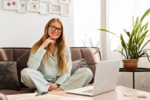 Front view of smiley woman in pajamas working at home