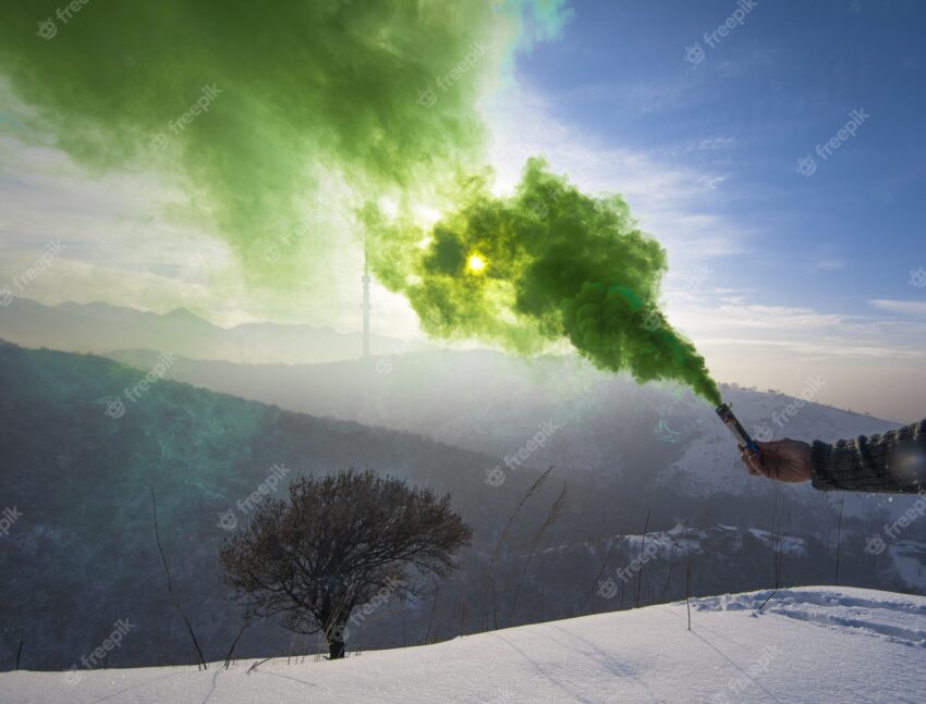 Green smoke bomb in hand
