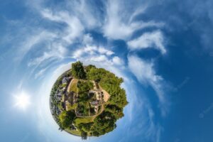 Green tiny planet in blue sky with beautiful clouds with transformation of spherical panorama 360 degrees curvature of space