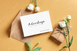 Greeting card mockup with envelope, gift box and white eustoma flowers