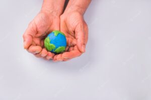 Hands of child holding colorful clay model of planet earth