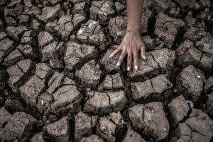 Hands on dry ground, global warming and water crisis