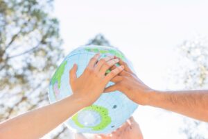 Hands holding planet model in nature