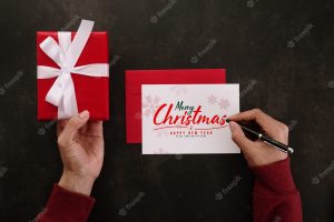 Hands writing merry christmas greeting card mockup