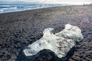 Ice pieces glitter like diamonds on black sand beach in winter season in iceland