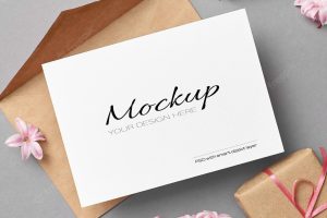 Invitation or greeting card mockup with pink envelope, gift box and hyacinth flowers