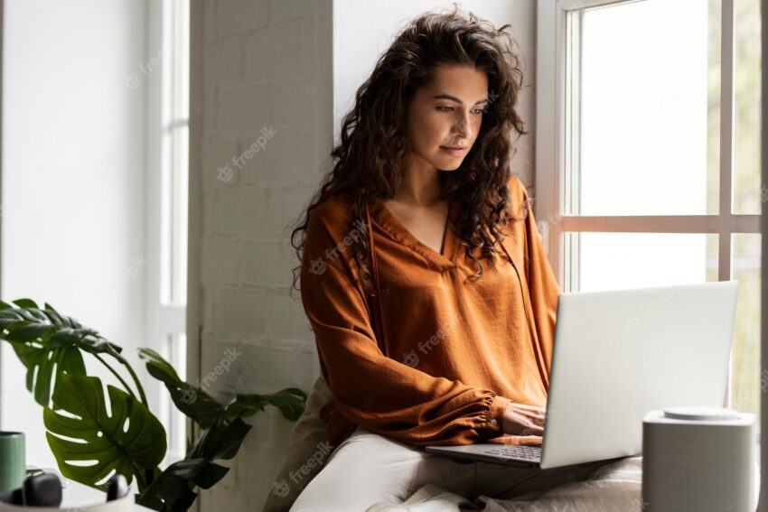 Medium shot woman working on laptop