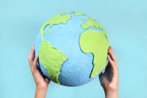 Paper style earth globe shape in hands