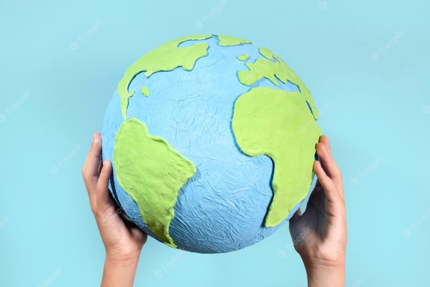 Paper style earth globe shape in hands