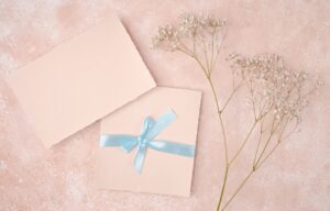 Pink arrangement with wedding invitation