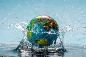 Planet earth in the form of a globe in transparent water with splashes
