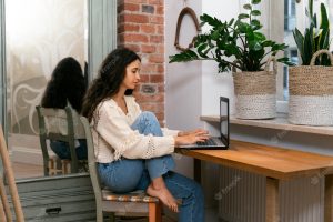 Side view woman working on laptop at home
