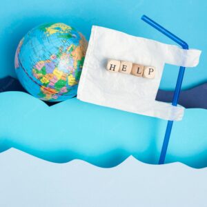 Top view of earth globe with plastic straw and paper ocean waves