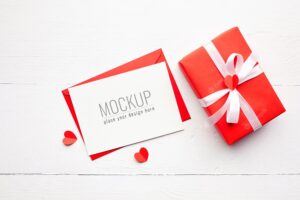 Valentines day card mockup with red gift box and hearts on white