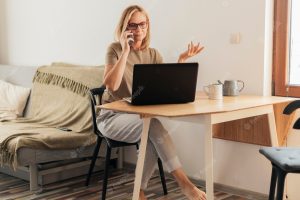 Woman working at home during quarantine with laptop and smartphone