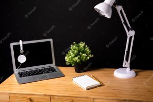 Wooden desk with lamp and laptop
