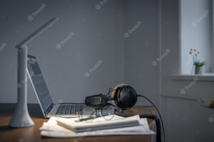 Workplace with headphones and laptop in the evening copy space