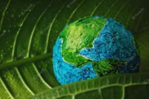 World earth day concept. green moisture leaf with droplet water embracing a handmade globe. environment to love and care