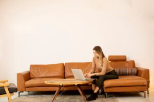 Young beautiful woman using a laptop on the sofa at home