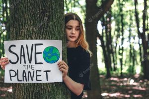 A young woman holds a poster with a call to save the planet