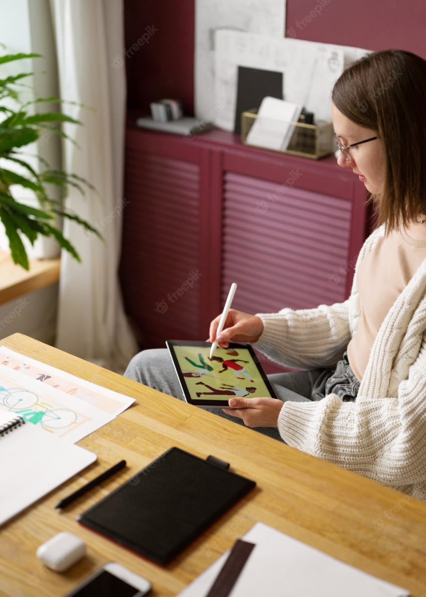 Adult female illustrator working on tablet device