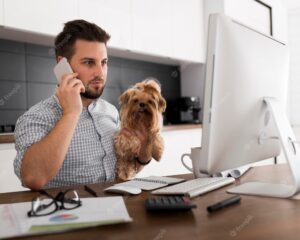 Casual adult male holding pet while working