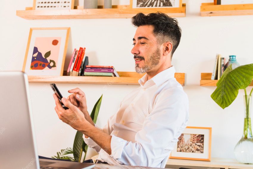 Close-up of businessman using mobile phone in the office