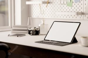 Portable tablet with wireless keyboard is on modern minimal white table minimal workspace