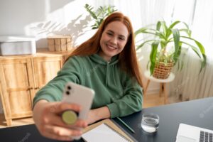 Portrait of woman using smartphone with pop socket outdoors
