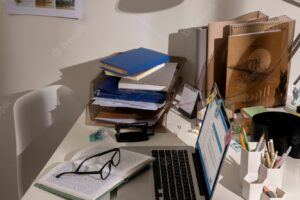 View of messy office workspace with laptop