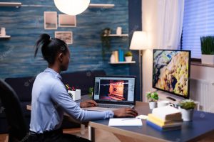 Young african woman gamer testing online professional game on laptop at home late at night. professional player checking digital video games on her computer with modern technology network wireless.