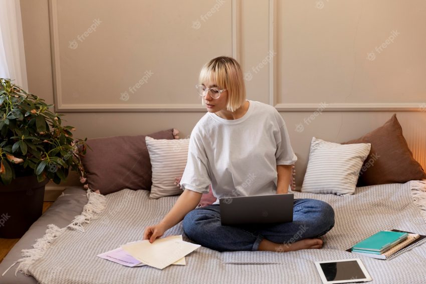 Young blonde woman working from home on her laptop